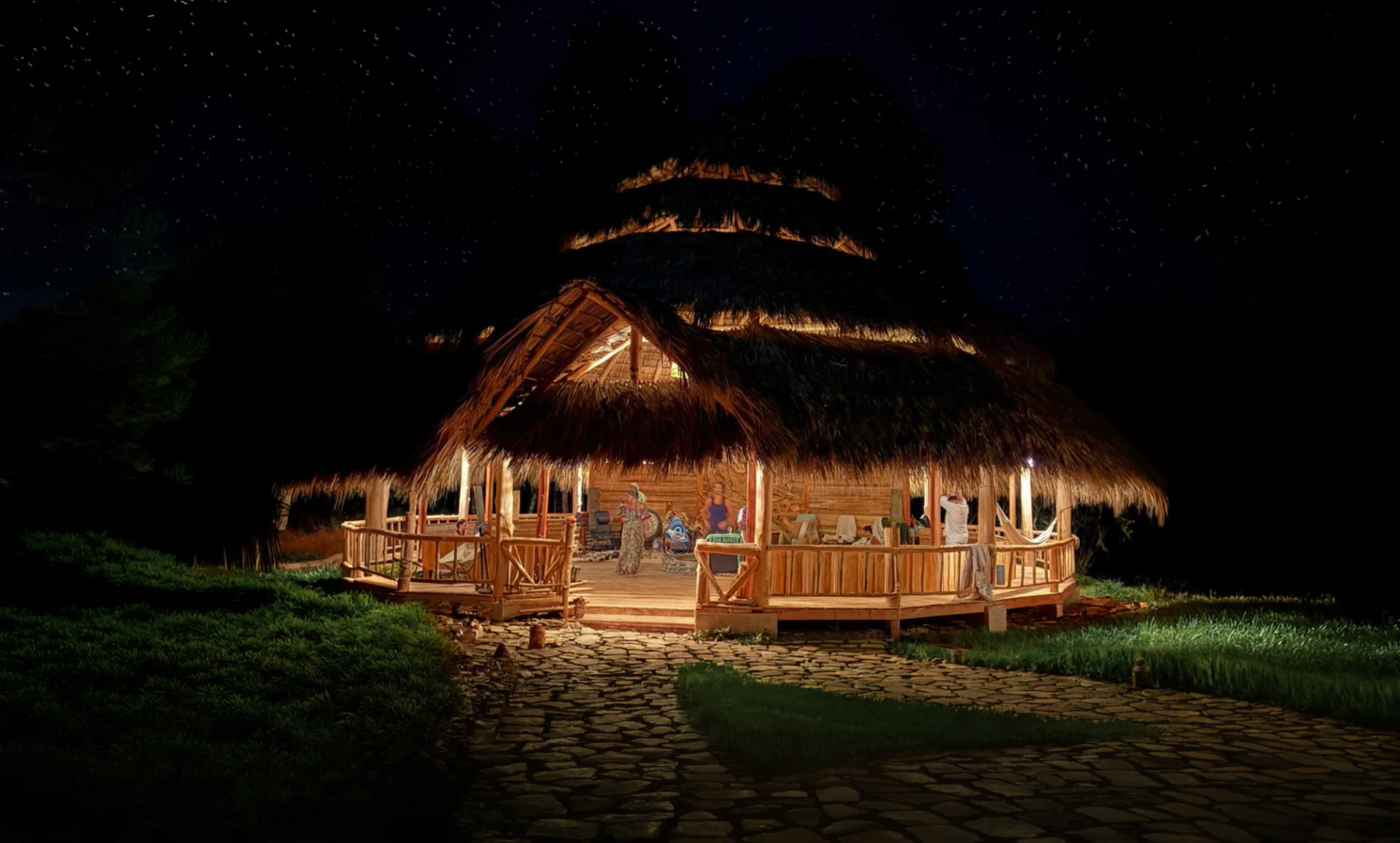 The Maloca at night, lit from within