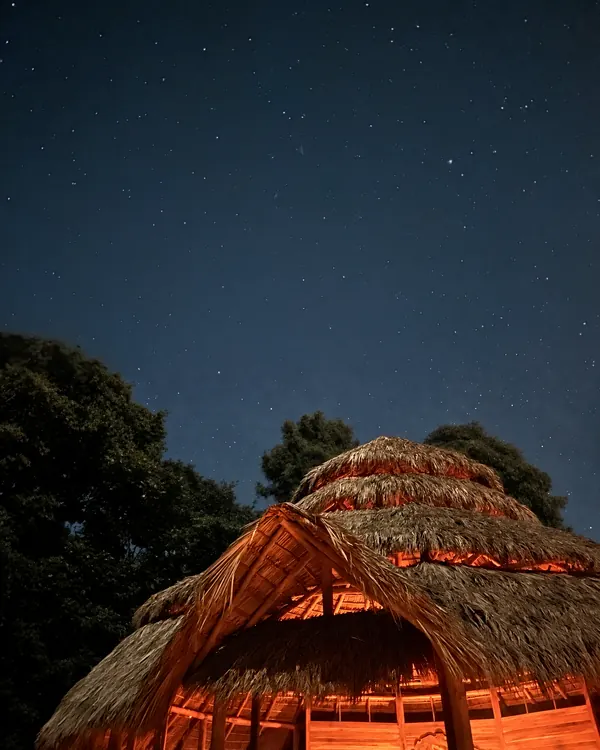 Inside the Maloca, the plant medicine ceremony space, with the fire circle at its centre