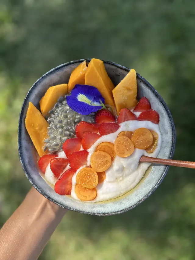 A breakfast bowl with fruit and flowers