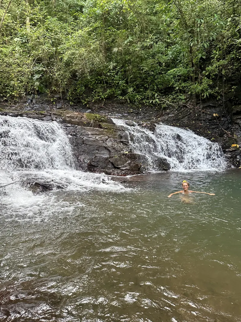 Swimming in a pool below a waterfall
