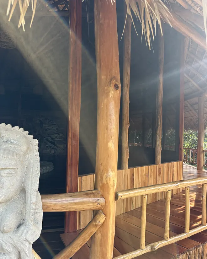 Wood, thatch and a carved statue at the Maloca