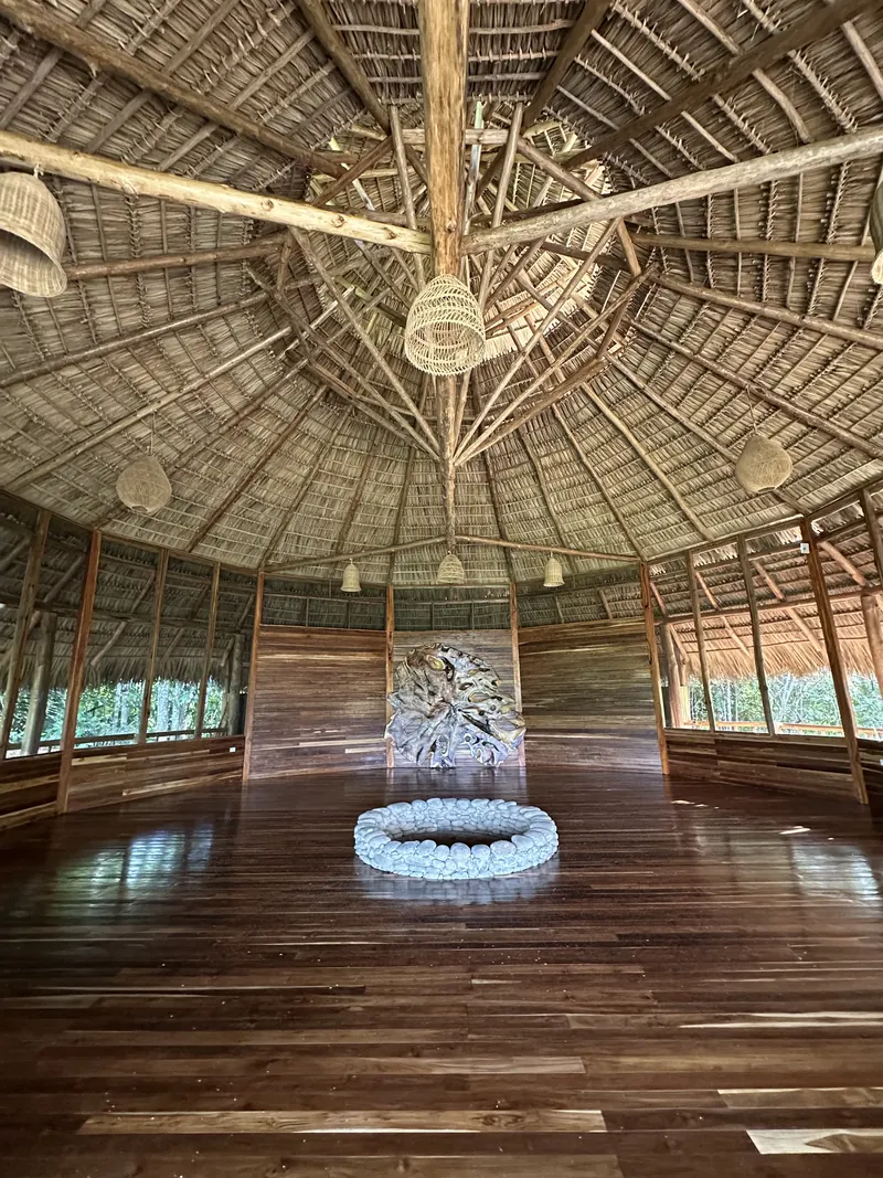 Inside the Maloca, the fire circle beneath the thatched roof