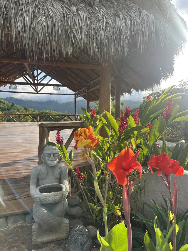 Flowers and a stone statue at the shala