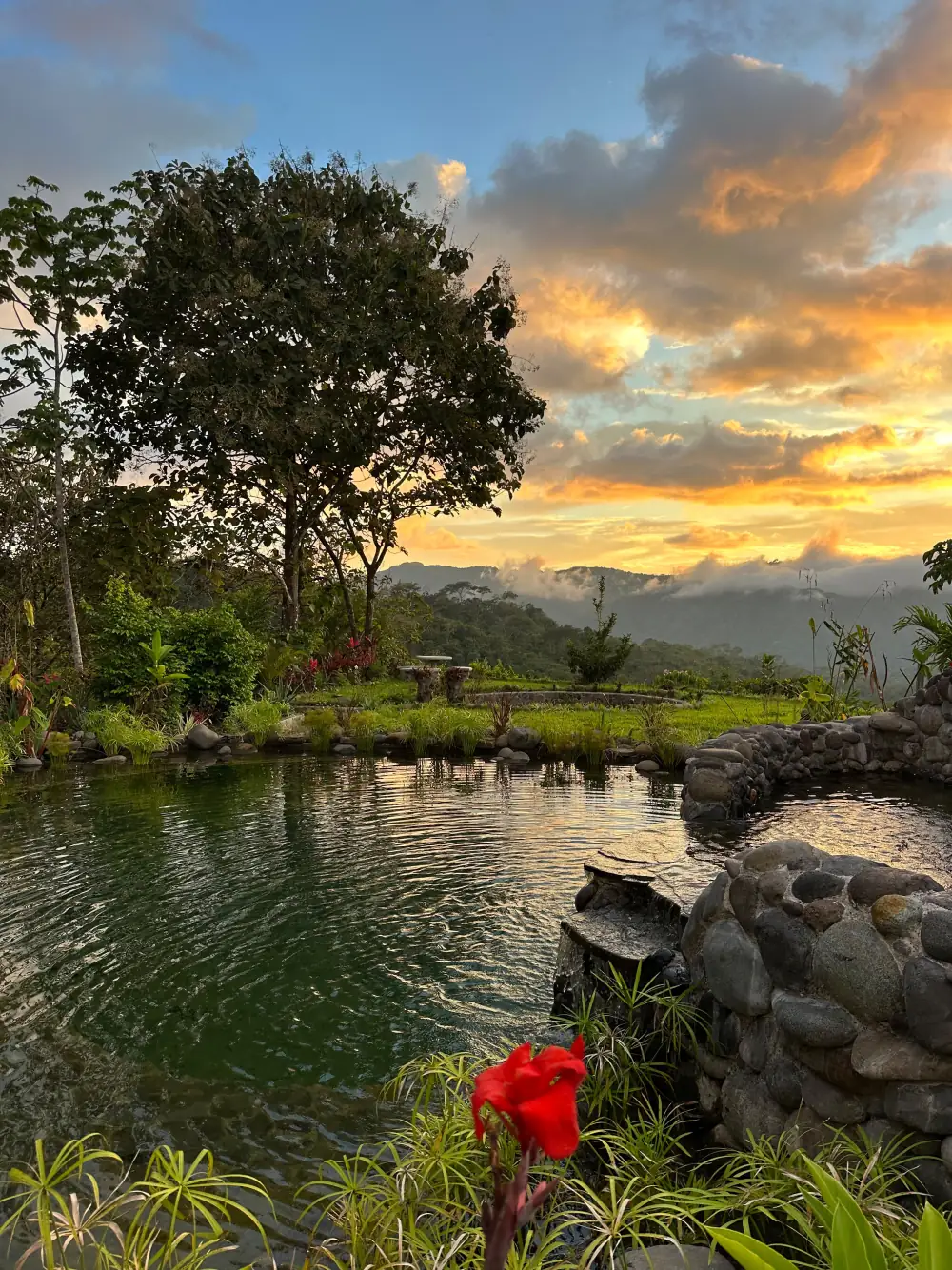 The natural pool at sunset, stone wall and mountains behind